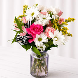 Pink rose and white daisy bouquet in a glass jar vase