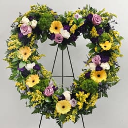 Heart-shaped floral wreath with yellow gerberas, lavender roses, and white roses