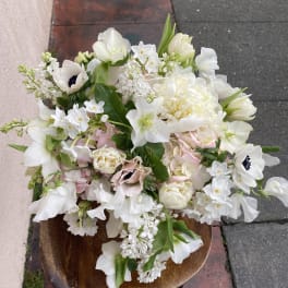 White and pale pink mixed bouquet in a wooden bowl