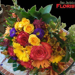 Mixed bouquet of roses, daisies, and other flowers in bright colors