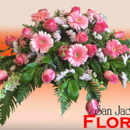 Pink roses and gerbera daisies in a low floral arrangement
