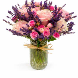 Pink roses and purple lavender in a glass jar vase