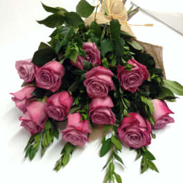 Bouquet of pink roses with greenery wrapped in burlap