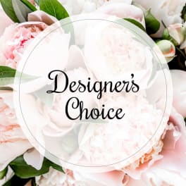 Soft pink and white peonies with green leaves behind a "Designer’s Choice" label
