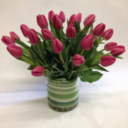 Pink tulips arranged in a striped glass vase