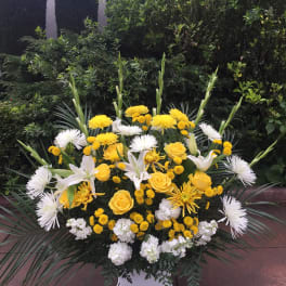 Yellow and white floral spray in a white container