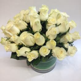 Bouquet of cream white roses in a round glass vase