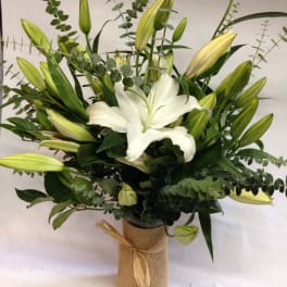 White lily bouquet in a burlap-wrapped vase