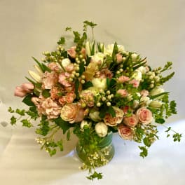 Blush and white floral arrangement in a green vase