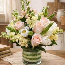 Bouquet of pale pink and white flowers in a glass vase