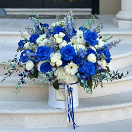 Blue and white rose bouquet in a white hat box with ribbon