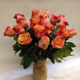 Bouquet of orange-pink roses in a burlap-wrapped vase