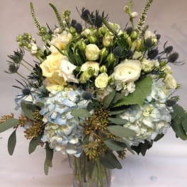 Bouquet of white and pale blue flowers in a glass vase