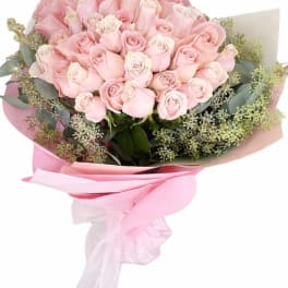 Bouquet of pale pink roses wrapped in pink paper