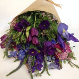 Bouquet of purple and pink flowers wrapped in burlap