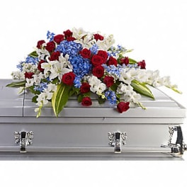 Red, white, and blue floral spray on a silver casket