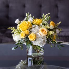 Yellow and white rose bouquet in a clear glass vase