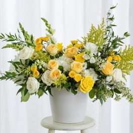 Yellow and white roses in a white vase