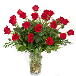 Red roses arranged in a clear glass vase
