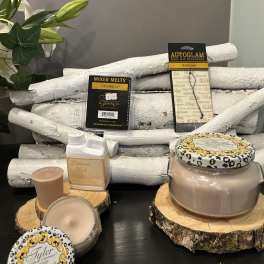 Assorted candles and fragrance products arranged on wood slices