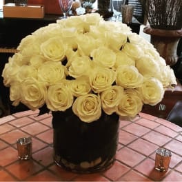 Large bouquet of cream roses in a black vase