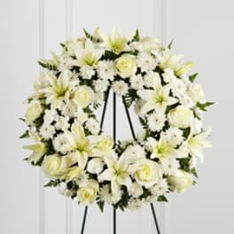 White floral wreath on a black stand