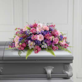 Pink and purple floral spray on a gray casket