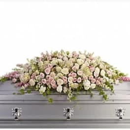 White and pale pink flowers arranged on a silver casket