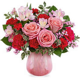 Pink roses and red carnations in a pink glass vase