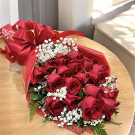 Bouquet of red roses with white baby's breath wrapped in red paper