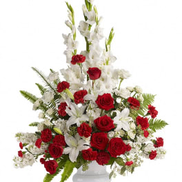 Red roses and white gladiolus in a white urn vase