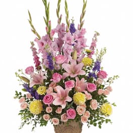 Pink lilies, roses, and yellow mums in an ornate vase