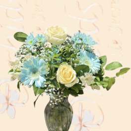 Blue daisies and cream roses arranged in a glass vase
