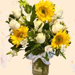Bouquet of sunflowers and white roses in a glass vase
