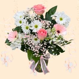 Pink roses and white daisies in a glass vase with a pink ribbon