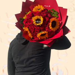 Bouquet of red roses and yellow sunflowers wrapped in red paper