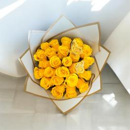 Bouquet of yellow roses wrapped in white and brown paper