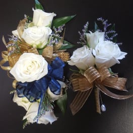 White rose corsages with gold and blue ribbon accents
