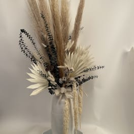 Tall dried floral arrangement in a white vase with pampas grass and cream accents