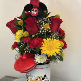 Bouquet of red roses and mixed flowers in a Mickey Mouse tin