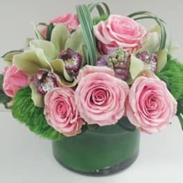 Pink roses and pale green orchids in a green vase