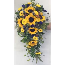 Cascade bouquet of yellow sunflowers and blue flowers with greenery