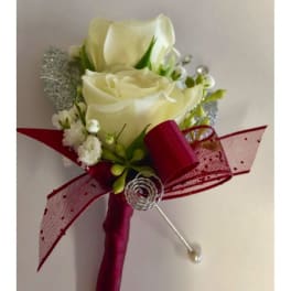 White rose boutonniere with red ribbon and pearl pin