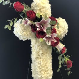 Cross-shaped floral tribute with red roses and white blooms
