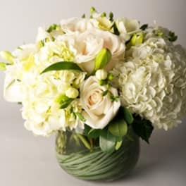 White floral bouquet in a green glass vase