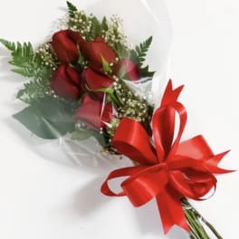 Bouquet of red roses wrapped in clear plastic with a red ribbon bow