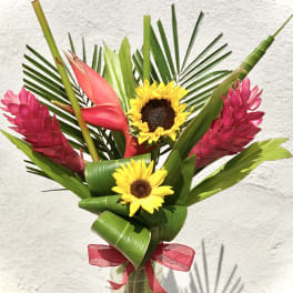 Tropical bouquet with sunflowers and pink ginger in a glass vase