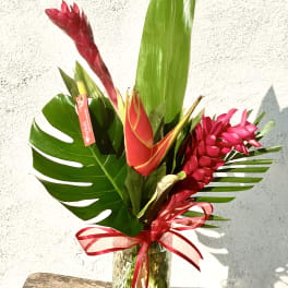 Tropical bouquet with red ginger flowers in a glass vase