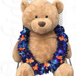 Plush teddy bear wearing a colorful flower lei