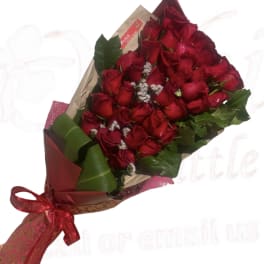 Bouquet of red roses wrapped in paper with a red ribbon